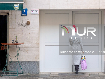 Woman In Red Hat Stands By White Doors With Shopping Bag