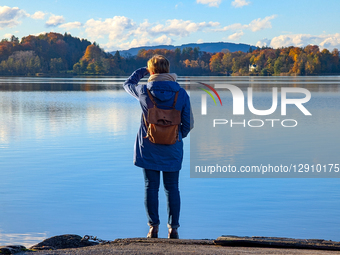 Woman Admire Autumn Landscape Of Lake From The Shore