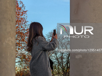 Woman Takes Picture With Smartphone Between Columns