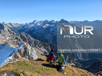 Hikers Resting On Benches At Alpine Summit
