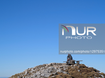 Hiker Sitting On Summit Bench