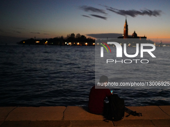 Young Man Using Smartphone At Night By The Water In Venice