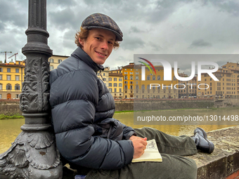 Young Man Sketching On Wall By The Arno River In Florence