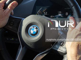  Driver's Hands On Steering Wheel In An Electric BMW