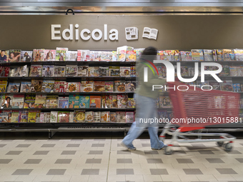 Woman Browsing Magazines And Newspapers At Supermarket Newsstand