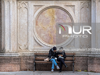 Young Women Use Smartphone On Bench By Marble Facade
