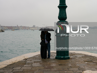 Couple Kisses Under Umbrella In Rain