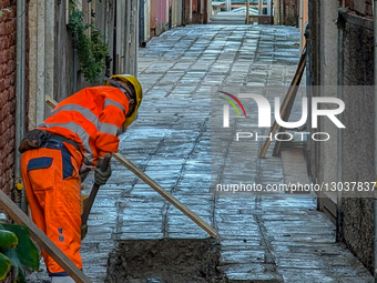 Construction Worker Repairs Pavement In Venice Alley