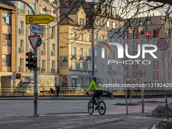 A Cyclist In A High-Visibility Safety Jacket And Helmet On A Munich Street