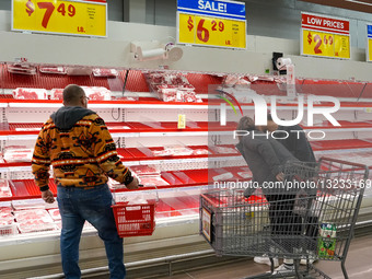 Shoppers browse partially empty shelves at an H-E-B grocery store in Frisco, Texas ahead of a forecast winter storm.