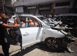 Palestinians Inspect Damaged Vehicles At The Site Of An Israeli Strike