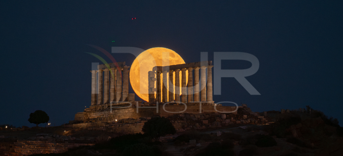 Editorial photography: The full moon, known as the ''Strawberry Moon,'' rises behind the ancient Temple of Poseidon at Cape Sounion, near Athens, Greece, on June 2...