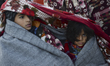 Two young refugees covered against the cold and wind, after another dinghy with over 20 re...