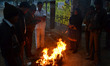 Indians warm themselves over a fire during a cold and rainy morning in Allahabad on Januar...