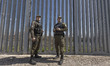 Greek border police officers patrol along the steel fence next to Evros river between Gree...