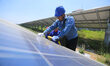 

A staff member is inspecting photovoltaic power generation equipment at a 49-megawatt ph...