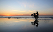 A Palestinian boy ride his motorcycle along the beach as the sun sets in Gaza City, on Feb...
