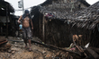 A gold mining worker walks a muddy ally toward to the pit at Blaay village in Camarines No...