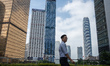 A man walks pass office buildings on October 25, 2023 in Hong Kong, China. John Lee today...