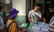 Workers distributing policy address booklets to the public on October 25, 2023 in Hong Kon...