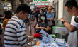 Workers distributing policy address booklets to the public on October 25, 2023 in Hong Kon...