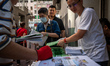 Workers distributing policy address booklets to the public on October 25, 2023 in Hong Kon...