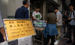 Workers distributing policy address booklets to the public on October 25, 2023 in Hong Kon...