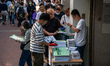 Workers distributing policy address booklets to the public on October 25, 2023 in Hong Kon...