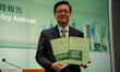 Hong Kong Chief Executive John Lee holding booklets of Policy address before a press confe...