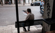 A man is ridding a newspaper on a bus station in the center of Athens, Greece on October 2...