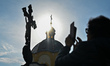 STARA SKVARIAVA, UKRAINE - OCTOBER 24, 2023 - The sun shines from behind a cross crowing a...