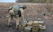 KHARKIV REGION, UKRAINE - OCTOBER 24, 2023 - An EOD expert places a metal detection on the...
