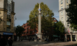 People sit on the bottom of the column that stands in the Seven DIals, Covent Garden, Lond...