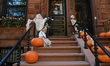 Creepy things with horns and skeletons with pumpkins cover the exterior of a townhouse in...