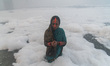 A Hindu devotee prays on the banks of river Yamuna amidst the Industrial toxic foam during...