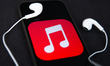 Headphones and Apple Music logo displayed on a phone screen are seen in this illustration...