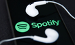 Headphones and Spotify logo displayed on a phone screen are seen in this illustration phot...