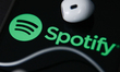 Headphones and Spotify logo displayed on a phone screen are seen in this illustration phot...