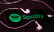 Headphones and Spotify logo displayed on a phone screen are seen in this illustration phot...
