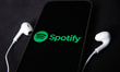 Headphones and Spotify logo displayed on a phone screen are seen in this illustration phot...
