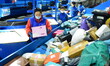 Staff members at an e-commerce logistics industrial park are sorting express parcels on an...