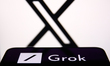 X logo displayed on a laptop screen and Grok logo displayed on a phone screen are seen in...