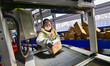 A staff member is using an automatic sorting system to sort express parcels at a courier c...