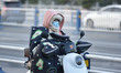 Citizens are wearing thick clothes and riding on a street in the cold wind in Fuyang City,...