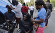 Haitian migrants are making dreadlocks and braids to pass the time outside a crowded shelt...