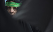 A female member of the Basij paramilitary force is standing guard during a military rally...