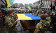 Ukrainian servicemen are holding the Ukrainian flag during a farewell ceremony for Ukraini...