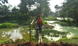 People are crossing a handmade wooden bridge made of bamboo on the outskirts of Kolkata, I...