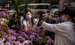A woman is picking flowers at the flower market in Hong Kong on February 1, 2024. 