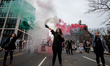 Protestors release smoke in Iran's colors during a protest against the Islamic regime in I...